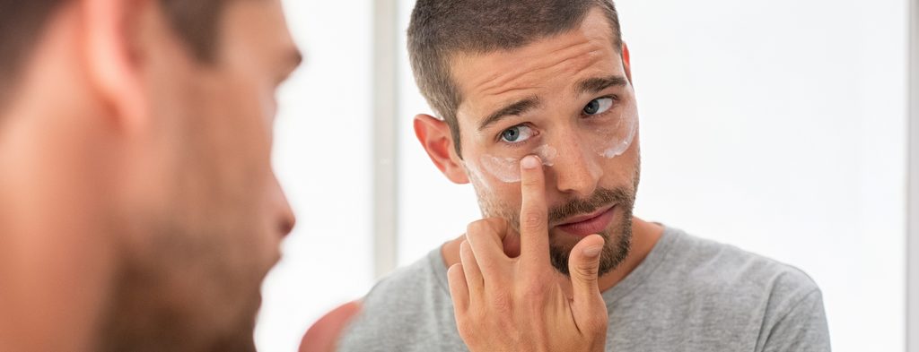 Man applying eye firming cream