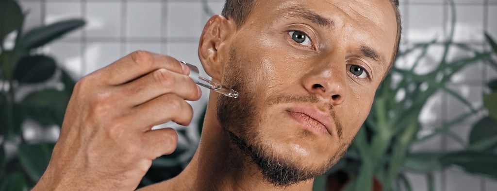 Man applying serum for treating wrinkles around mouth