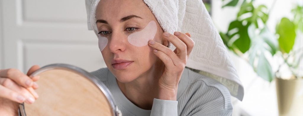 Woman applying eye patch 