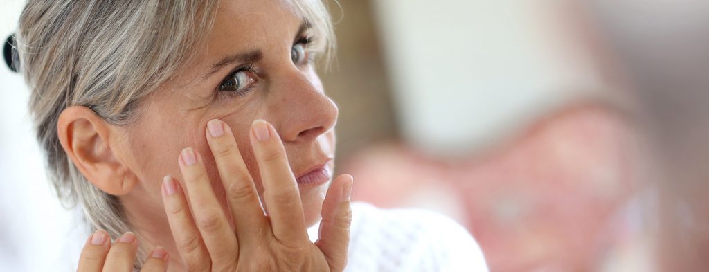 Woman applying anti aging cream for wrinkles