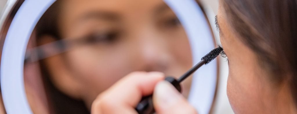Woman applying mascara on eyelash